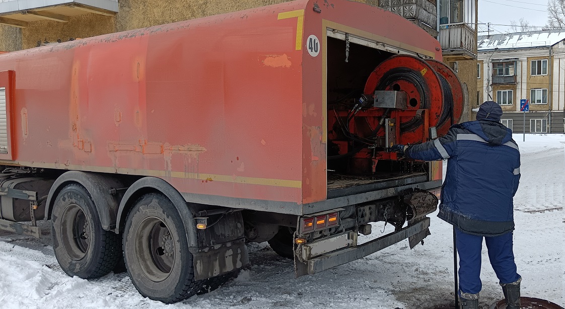 Каналопромывочная машина и работник прочищают засор в канализационной системе в Бирюсинске